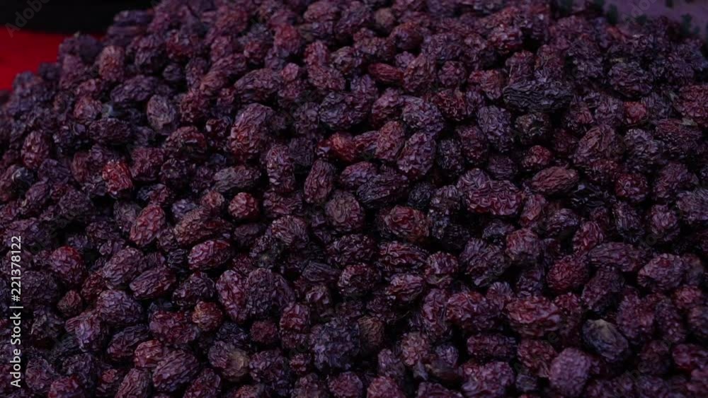 A man gathers a large pile of raisins in this close up shot A man gathers a large pile of raisins in this close up shot