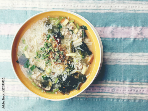 rice soup with vegetables, chickenin and pork in white bowl. Thai style food. photo