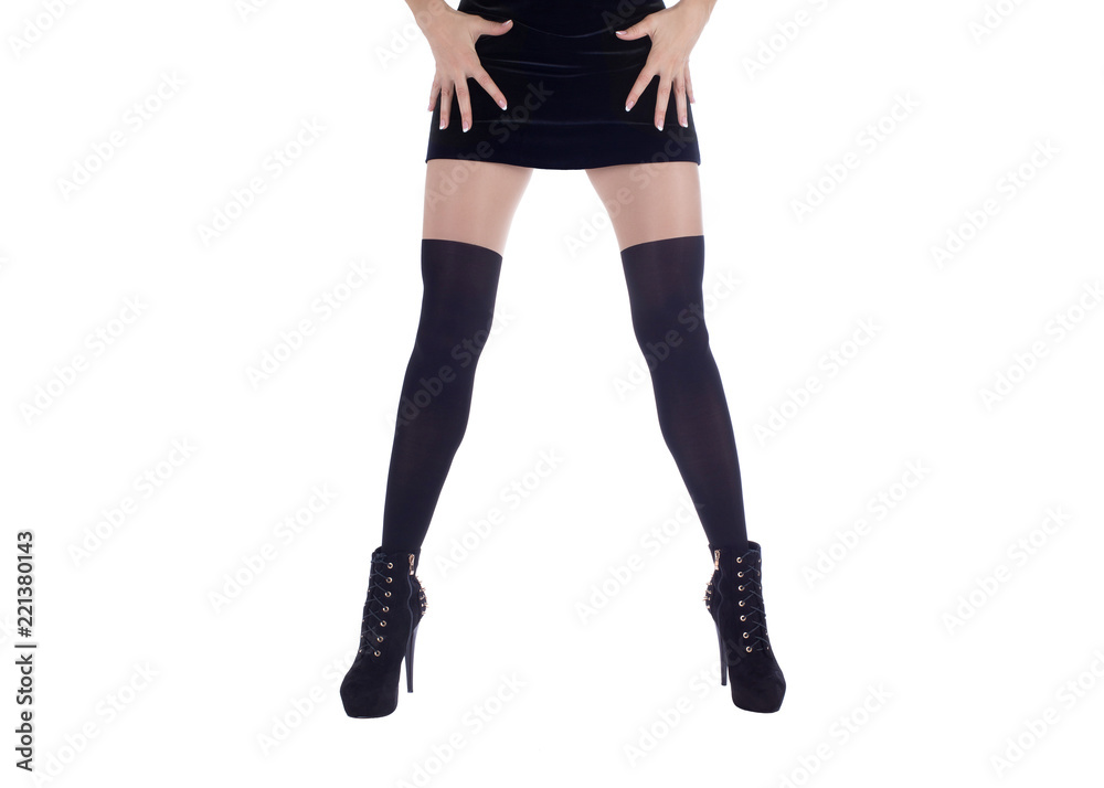 Long slim female legs in black spats, fitting dress and ankle boots. Isolated on white Long slim female legs in black spats, fitting dress and ankle boots. Isolated on white