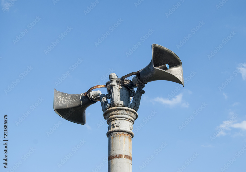 Old retro loudspeaker on a blue sky background. Old retro loudspeaker on a blue sky background.