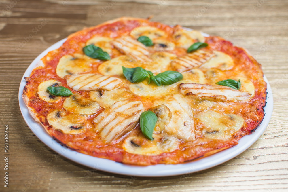 pizza with basil on a white plate pizza with basil on a white plate