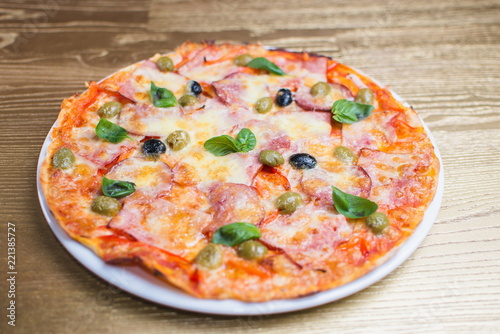 pizza with basil on a white plate