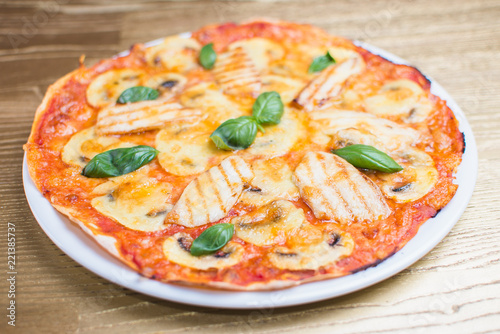 pizza with basil on a white plate