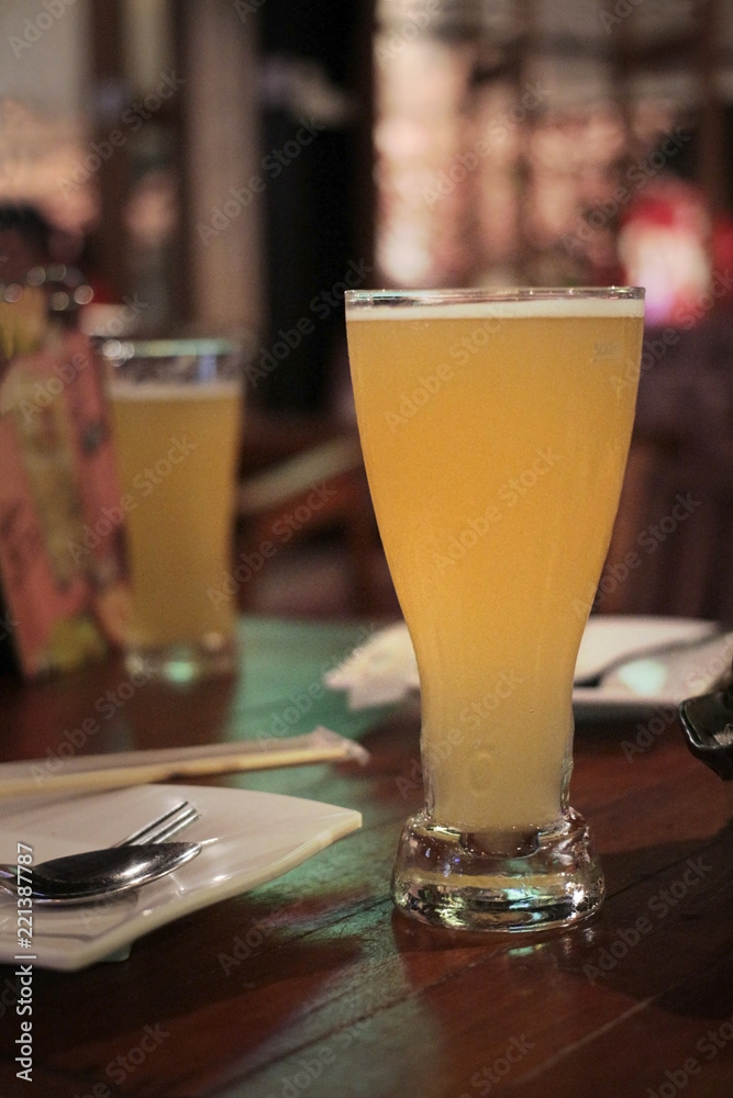two glasses of pilsner beer on the red table two glasses of pilsner beer on the red table