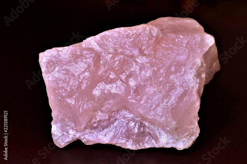 Piece of Rose quartz on a dark background, natural untreated mineral. 