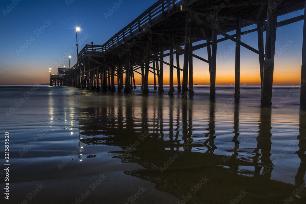 Sun setting at dusk behind the Newport beach pier California