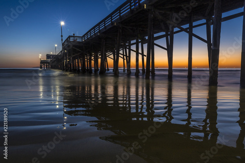 Sun setting at dusk behind the Newport beach pier California © Jeremy
