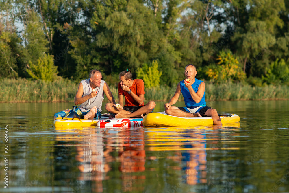 Happy friends, a SUP surfers relax