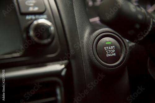 Car Push start.Closeup a start button of a car while steering the car.finger pressing the Engine start stop button of a car. © kanpisut