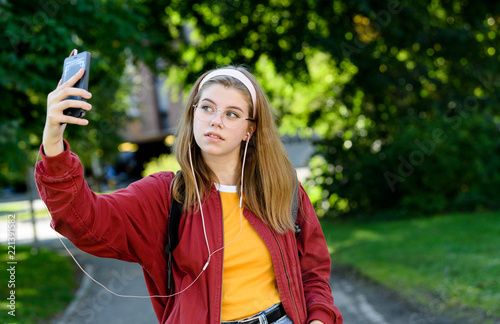 Young girl taking selfie while listening to music photo