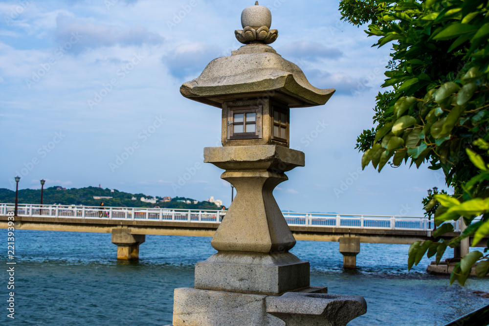 Stone carved Japanese lantern whit a bridge on the background