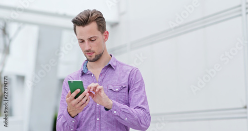 Young man use of mobile phone in the city