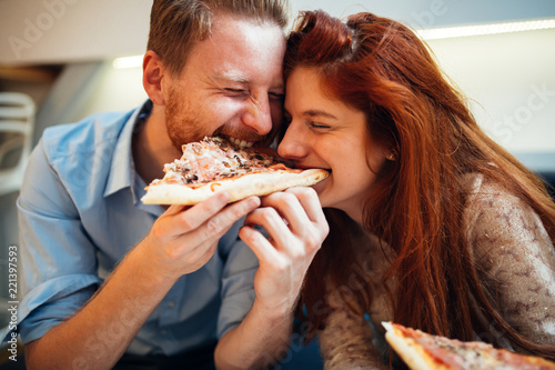 Couple sharing pizza and eating