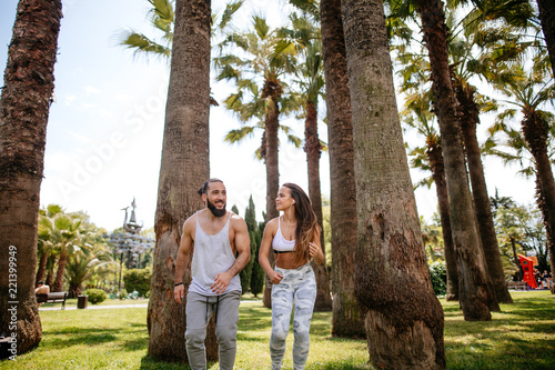 Athletic couple running in the tropical park. Sport runners jogging in tropical garden working out, feeling mood to do theit best in this morning, Fitness exercise concept. photo