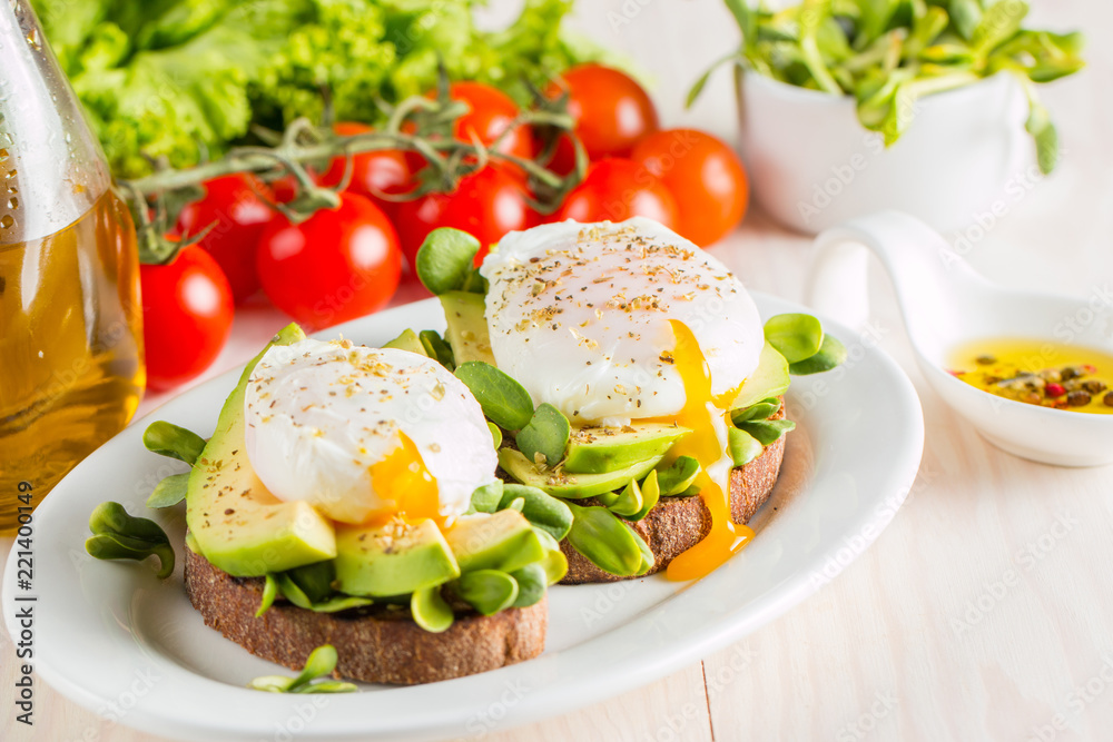 Avocado toast, cherry tomato and poached eggs on wooden background. Breakfast with vegetarian food, healthy diet concept. Avocado toast, cherry tomato and poached eggs on wooden background. Breakfast with vegetarian food, healthy diet concept.