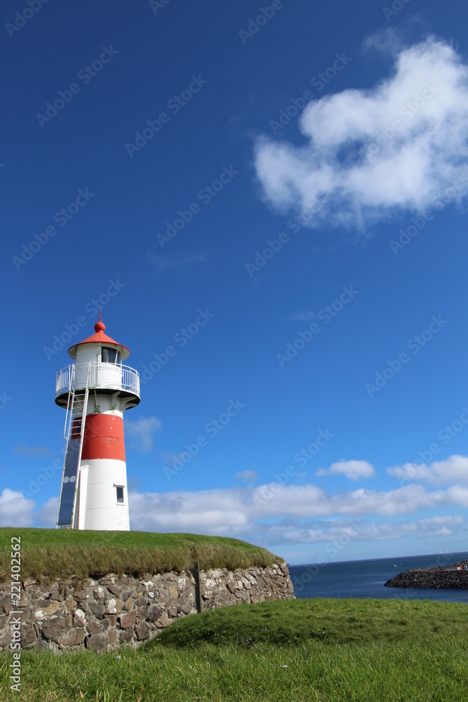 Red and white lighthouse in Torshavn, faroe islands. Sunny summer day