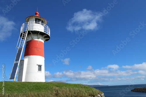 Red and white lighthouse in Torshavn, faroe islands. Sunny summer day