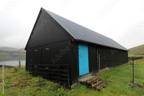  Black barn with blue door; wideangle view; faroe islands