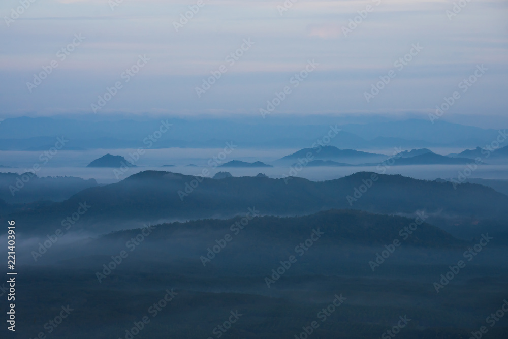 In the morning mountain range with visible silhouettes throug with fog