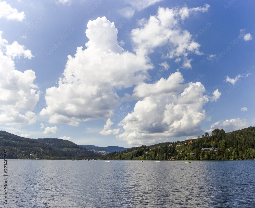 Heap clouds in the blue sky over the Titisee in the Black Forest