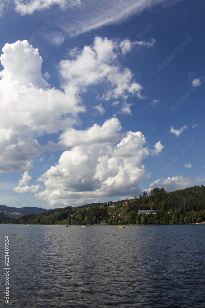 Heap clouds in the blue sky over the Titisee in the Black Forest