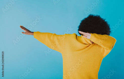 Woman dabbing on colored backgrounds. young adult with afro haircut making the dab move