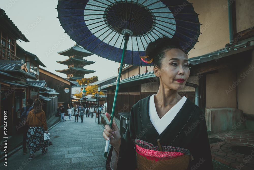 Fototapeta premium Beautiful japanese senior woman walking in the village. Typical japanese traditional lifestyle