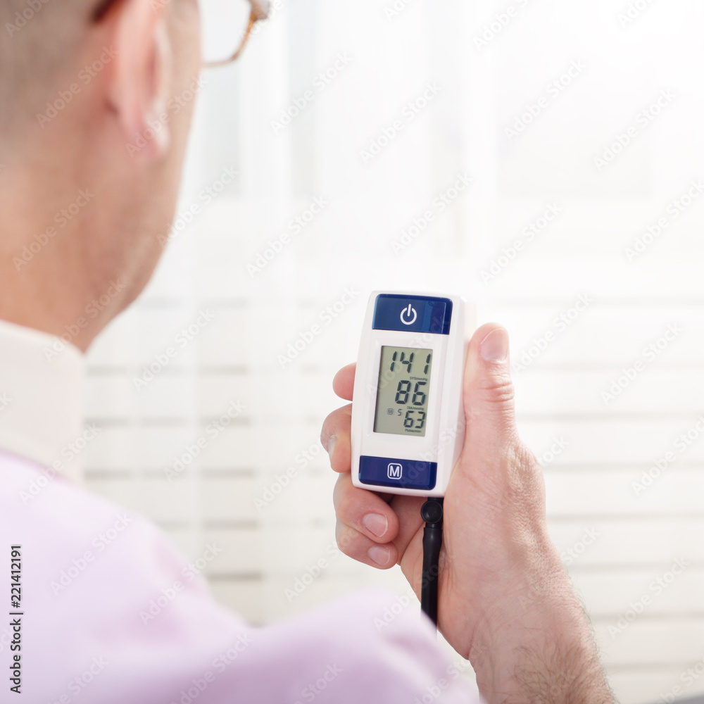 Man read measurement result from digital blood pressure monitor Man read measurement result from digital blood pressure monitor