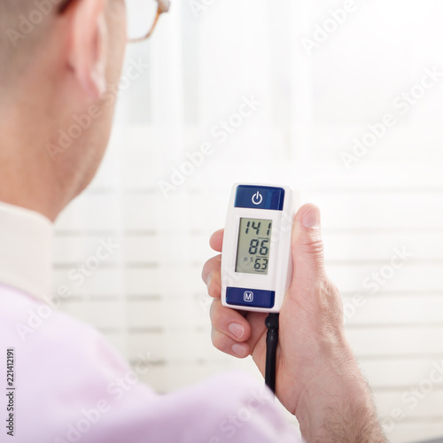 Man read measurement result from digital blood pressure monitor