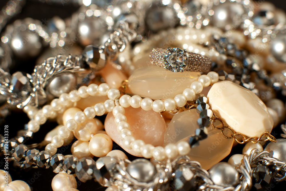 Jewelry in a pile. Macro. Many jewelry shines on a black background. Bijouterie is a kind of accessories for women's fashion. Jewelry in a pile. Macro. Many jewelry shines on a black background. Bijouterie is a kind of accessories for women's fashion.