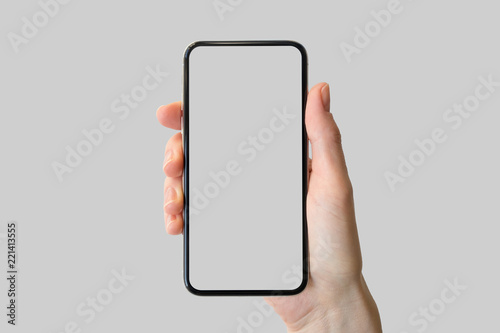 Hand holding bezel-free / frameless modern smartphone in front of neutral background