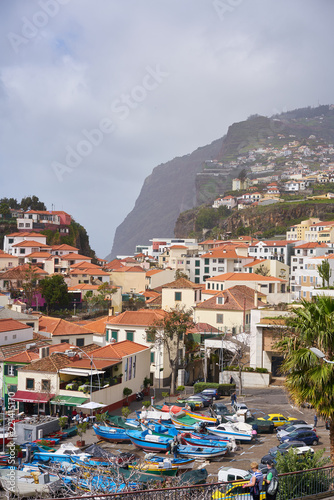 View of Câmara de Lobos in Madeira with Cape Girão on the background and boats at the marina © Luis