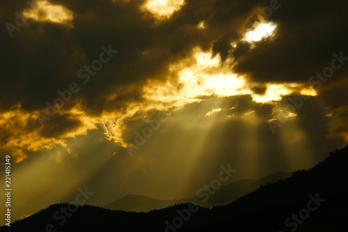 clouds with sunbeams. silhouettes of mountains and clouds at dawn