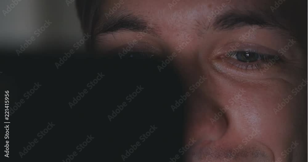 close up young man using smartphone at dart room at home. . Reflection from the smartphone on his face close up young man using smartphone at dart room at home. . Reflection from the smartphone on his face