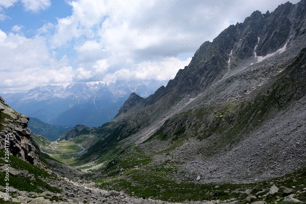 Fototapeta premium panorama montagna natura cielo nubi azzurro cime rocce vallata veduta verde prato erba 