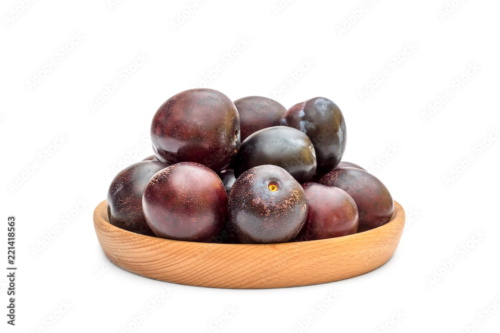 Obraz premium Wooden bowl with ripe plums on white. Top view.