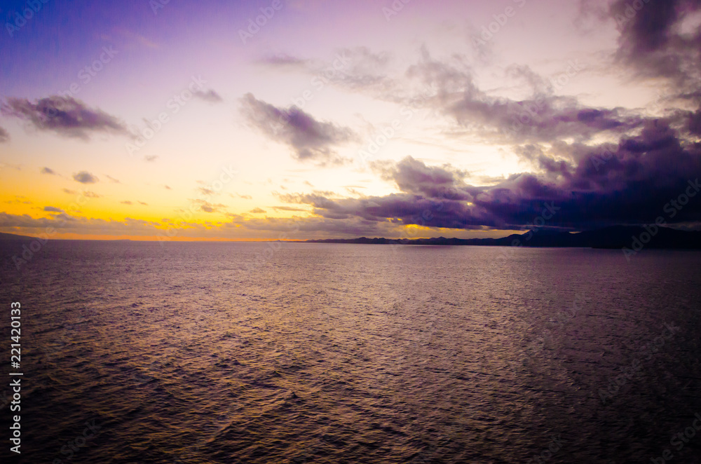 Obraz premium Blue orange sunset on empty peaceful quiet ocean water in pacific atlantic sea for ship cruise family vacation and holiday