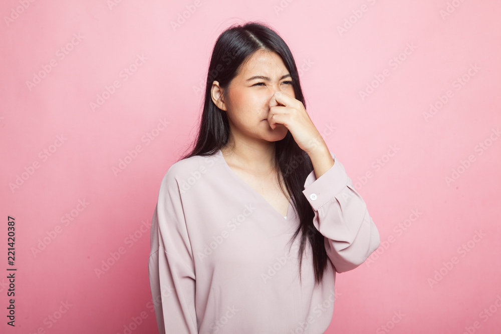 Young Asian woman holding her nose because of a bad smell. Young Asian woman holding her nose because of a bad smell.