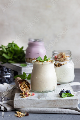 Jars with healthy yogurt with fresh blueberries, granola and mint. Tasty parfaits