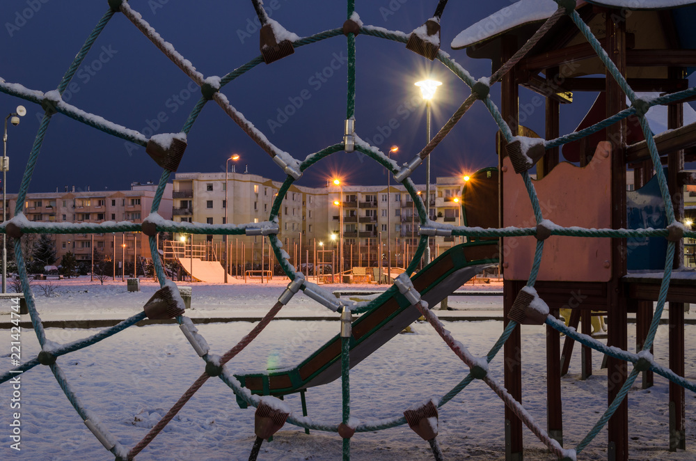 WINTER IN CITY - Snow-covered playground for children in a residential complex at dawn in Kolobrzeg

