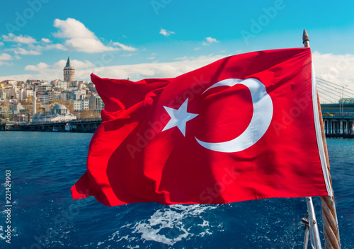 Photography Turkish flag waving on a boat and Galata Tower on the background in Istanbul