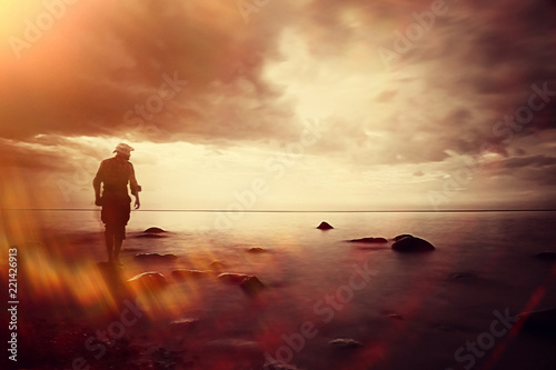 landscape sunset on the sea  man on the lake shore at sunset  beautiful place  nature  water and seashore  concept of waiting for loneliness