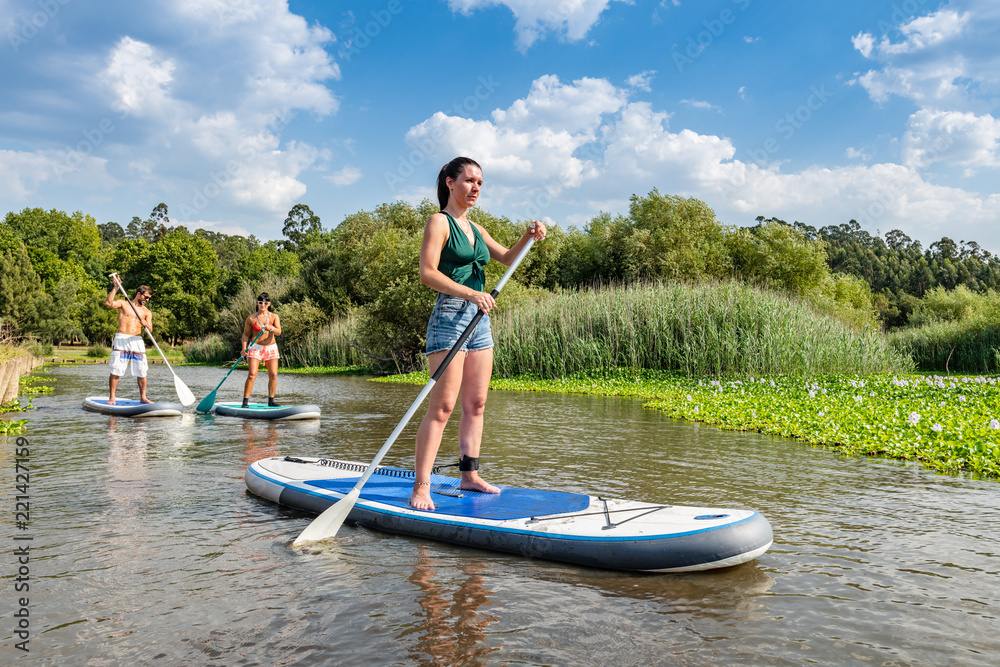 Man and women stand up paddleboarding Man and women stand up paddleboarding