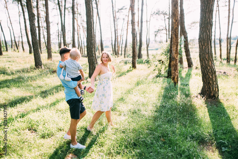 A cute family - mom, dad and son spend fun time in nature A cute family - mom, dad and son spend fun time in nature