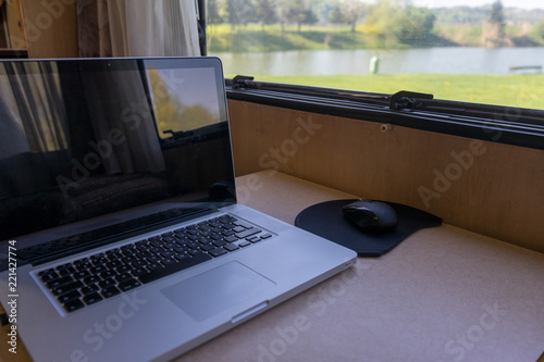 Mesa de trabalho dentro de autocaravana/motorhome com vista para lago