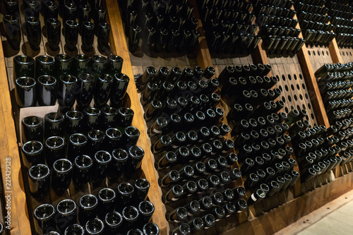 Bottiglie di vino inserite  negli  scaffali di una cantina vinicola photo
