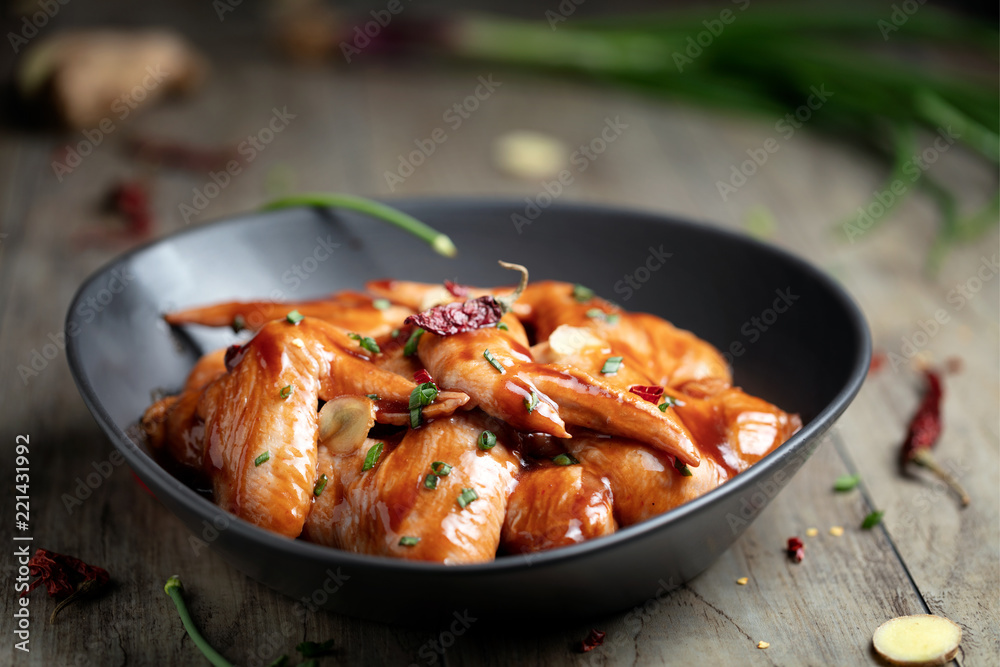 Raw Marinated chicken wings for BBQ, with green onion and dry red pepper Raw Marinated chicken wings for BBQ, with green onion and dry red pepper