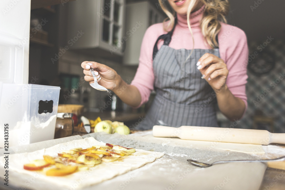 happy woman, mother is preparing a pie in the kitchen at home. concept of happy family and home coziness happy woman, mother is preparing a pie in the kitchen at home. concept of happy family and home coziness