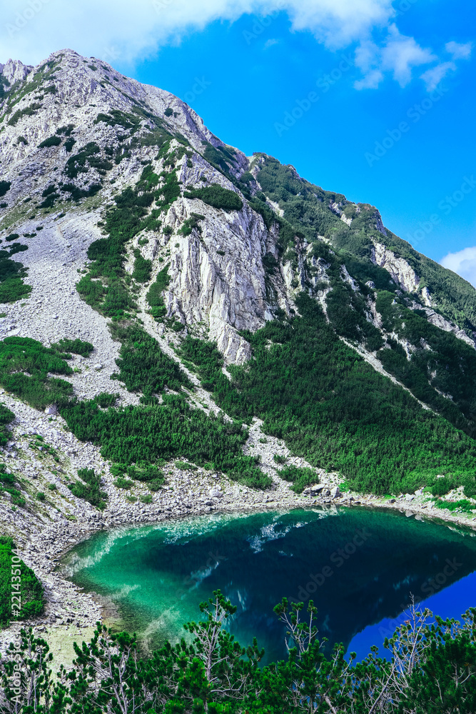 Amazing alpine lake in the high mountains. Beautiful fiord mountain, river, hiking scenic landscape, summertime.
