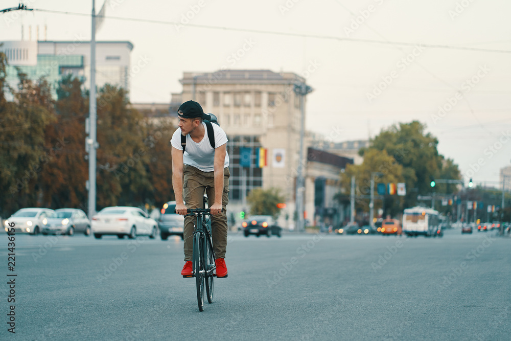 Fototapeta premium Man riding bicycle in urban city holding hands on handlebar